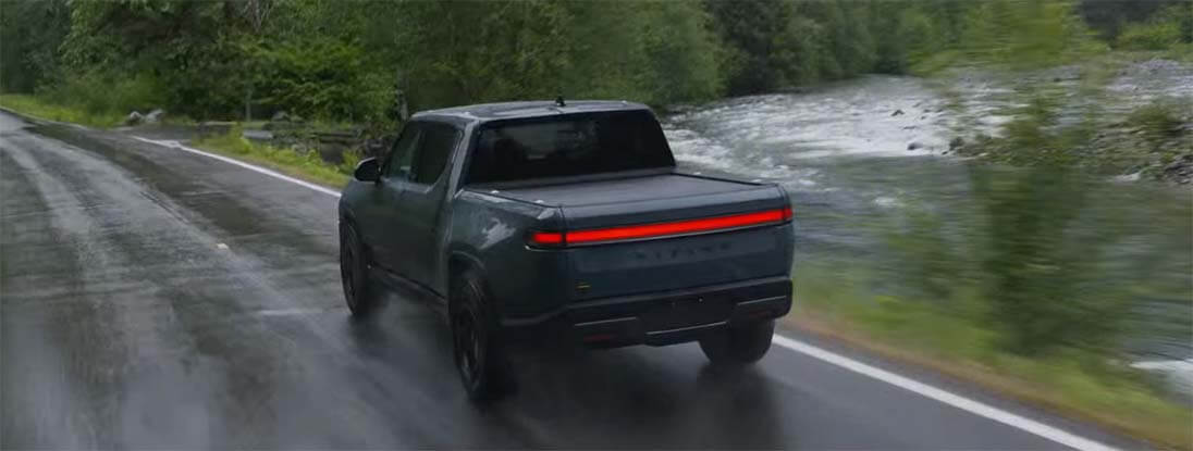 An overhead view of the 2025 Rivian R1T driving down a forest road.